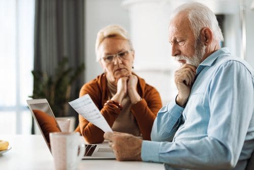 Mature Couple Working On Their Home Finances At Home and wondering Does Medicare Pay For Long-Term Care?