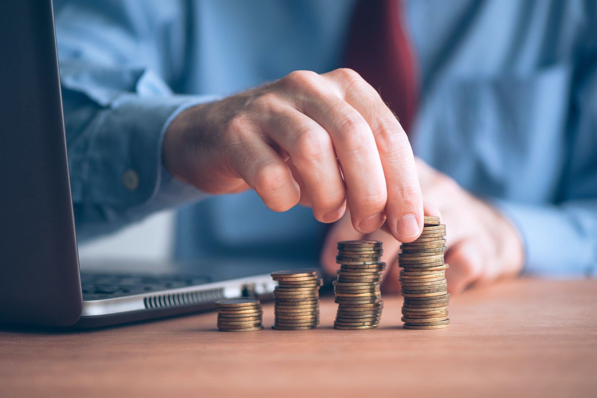 Man stacking money to represent the increase of yearly Manhattan Life Medicare Supplement