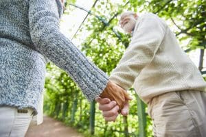 Seniors in Texas holding hands and walking as they discuss the specifics of Medicare Part N