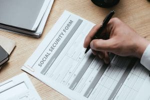 Person filling out social security forms.