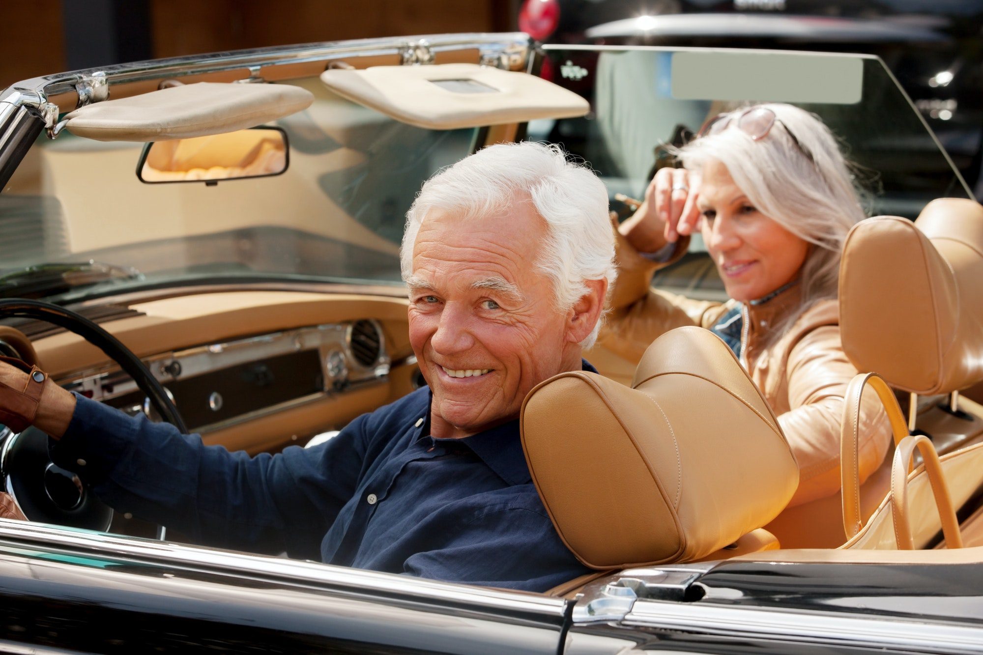 Senior couple enjoying a drive in care while they discuss the new 2022 medicare costs.