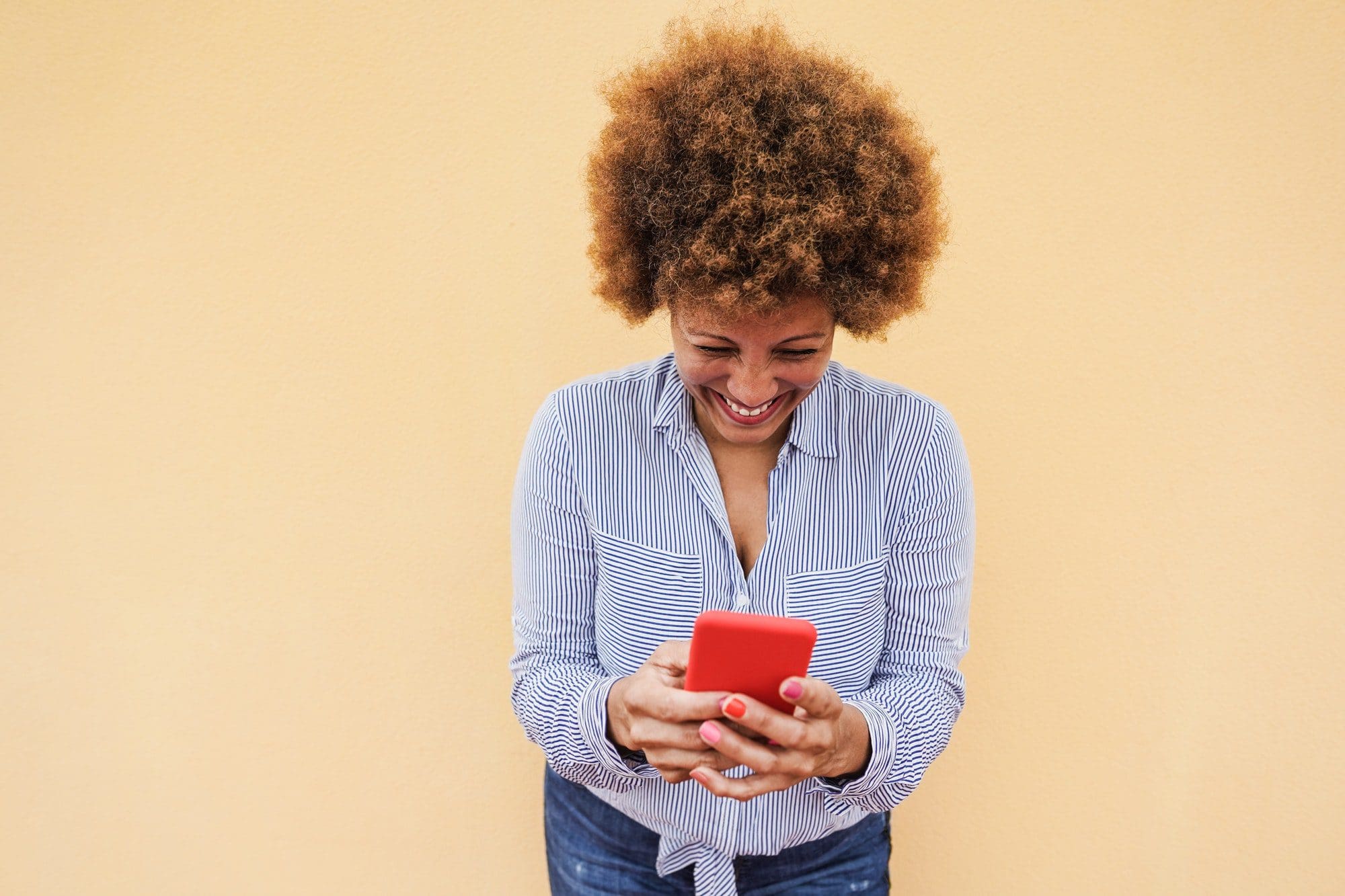 Happy senior woman using mobile phone as she discusses Medigap insurance rates with friends.
