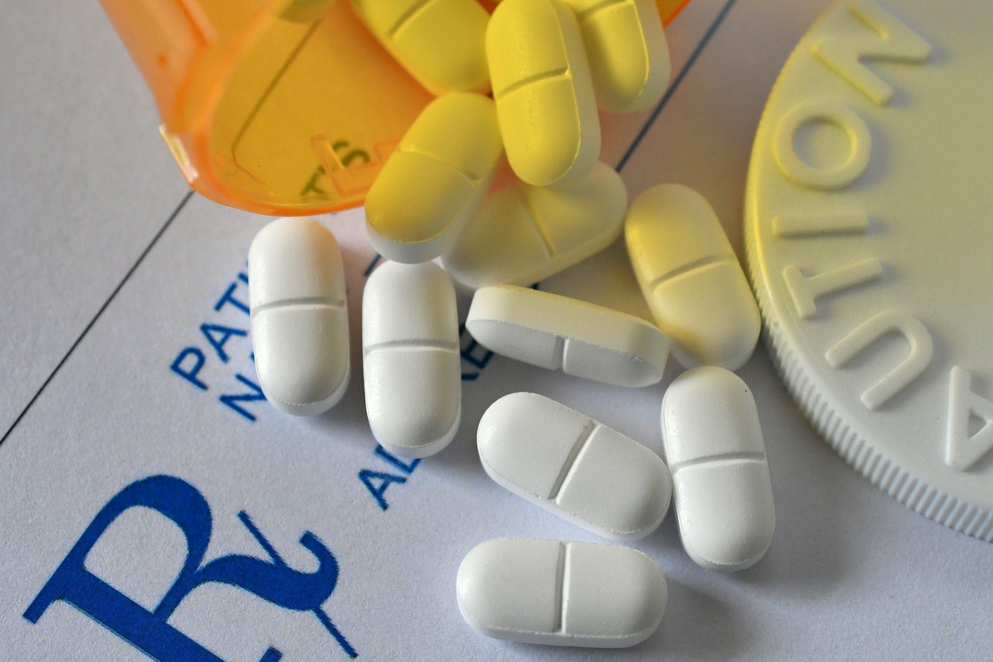 White pain pills medicine pharmaceutical laying on a prescription drug plan